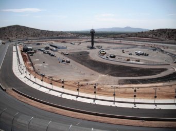 A wide view of a race track with a control tower in the background.